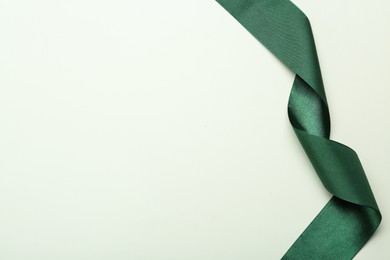 Beautiful green ribbon on white background, top view. Space for text