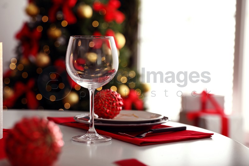 Festive table setting and Christmas tree in stylish room interior