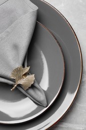 Photo of Plates with gray fabric napkin and decorative ring for table setting, top view