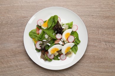 Delicious salad with boiled egg, radish and cheese on wooden table, top view