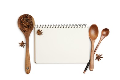 Blank recipe book, anise stars and wooden spoons on white background, top view. Space for text