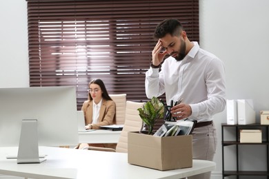 Dismissed man packing personal stuff into box in office