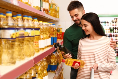 Photo of Young couple with shopping basket in supermarket