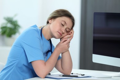 Photo of Exhausted doctor sleeping at workplace in hospital