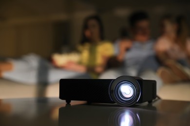 Family watching movie at night, focus on video projector
