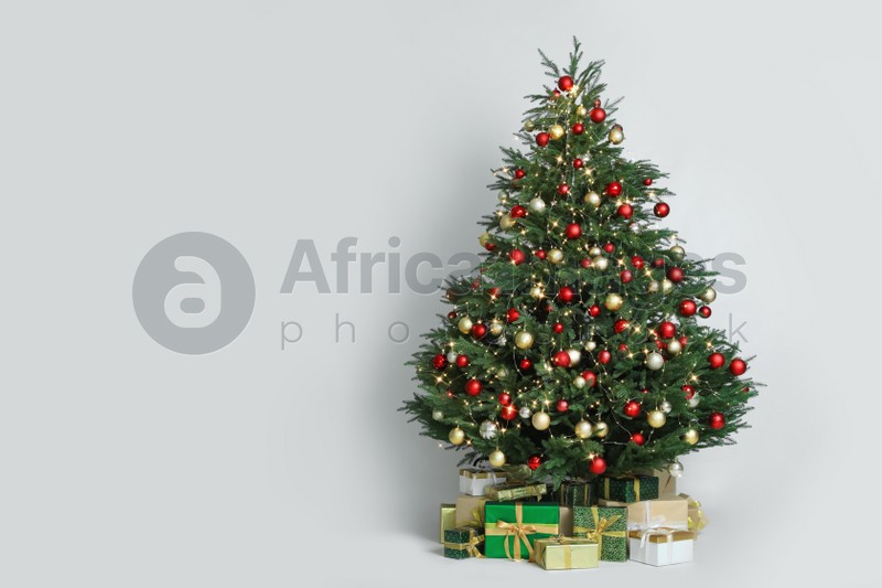 Beautiful Christmas tree with gift boxes on white background