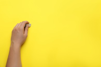 Man erasing something on yellow background, closeup. Space for text