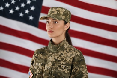 Female American soldier with flag of USA on background. Military service