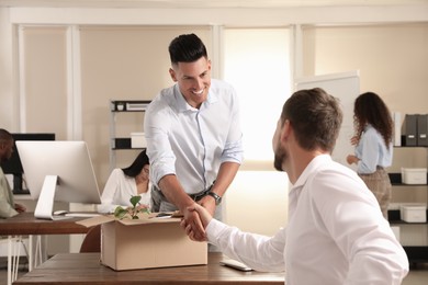 Employee shaking hand with new coworker in office