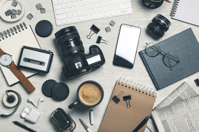 Flat lay composition with equipment for journalist on light table