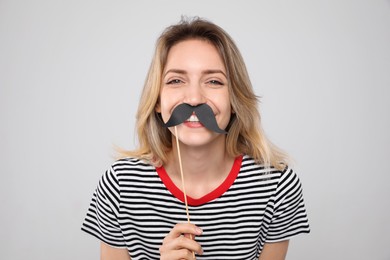 Photo of Funny woman with fake mustache on grey background