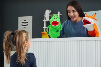 Mother performing puppet show for her daughter at home
