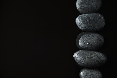 Stones in water on black background, flat lay with space for text. Zen lifestyle