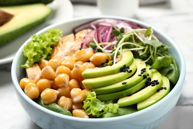 Delicious avocado salad with chickpea on white table, closeup