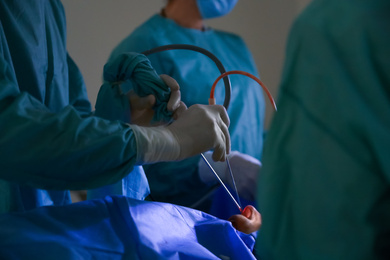 Professional doctors performing 
operation in surgery room, closeup