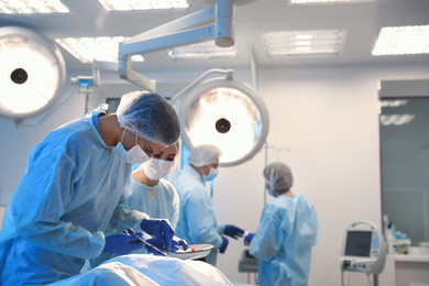 Photo of Team of professional doctors performing operation in surgery room