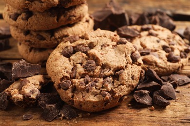 Many delicious chocolate chip cookies on wooden table, closeup