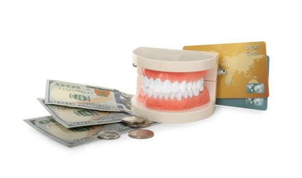 Educational dental typodont model, money and credit cards on white background. Expensive treatment