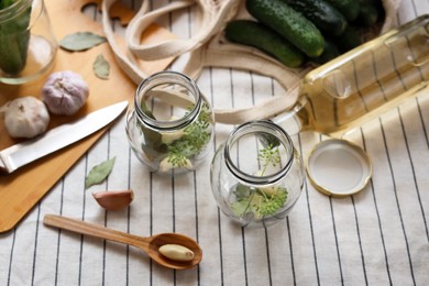 Empty glass jars and ingredients prepared for canning on tablecloth, above view