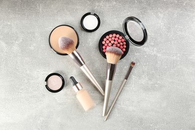 Flat lay composition with makeup brushes on grey stone table