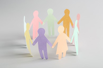Photo of Paper human figures making circle on white background. Diversity and Inclusion concept