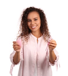 Young African American woman with menstrual cup and tampon on white background