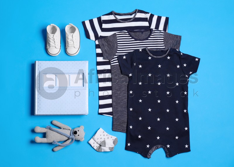 Photo of Flat lay composition with baby clothes and accessories on blue background