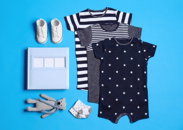 Flat lay composition with baby clothes and accessories on blue background