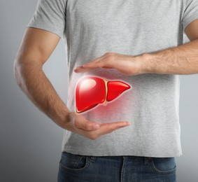 Man and illustration of healthy liver on grey background, closeup