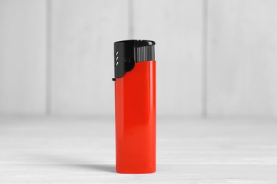 Photo of Stylish small pocket lighter on white wooden table
