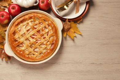 Delicious homemade apple pie and autumn leaves on wooden table, flat lay with space for text. Thanksgiving Day celebration