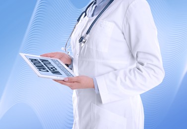 Doctor holding modern tablet with phrase Candida Infection on light blue background, closeup