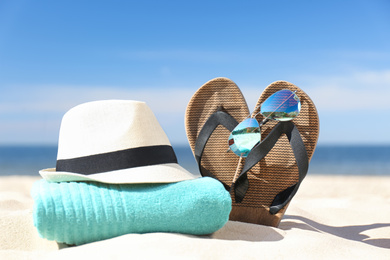 Stylish beach accessories for summer vacation on sand near sea