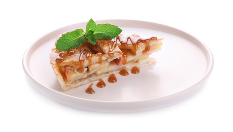 Slice of traditional apple pie with mint and syrup isolated on white