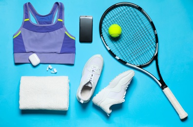 Stylish sportswear and equipment on light blue background, flat lay