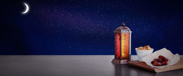 Image of Traditional Ramadan lantern and dry fruits on table, banner design. Muslim holiday