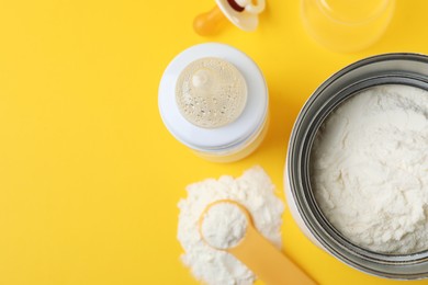 Flat lay composition with powdered infant formula on yellow background, space for text. Baby milk