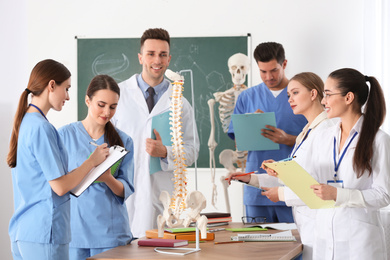 Medical students studying human spine structure in classroom