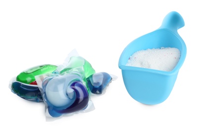 Laundry capsules and measuring scoop of washing powder on white background