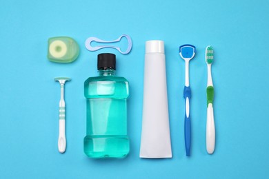 Flat lay composition with tongue cleaners and teeth care products on light blue background