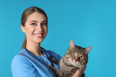 Veterinarian doc with cat on color background. Space for text