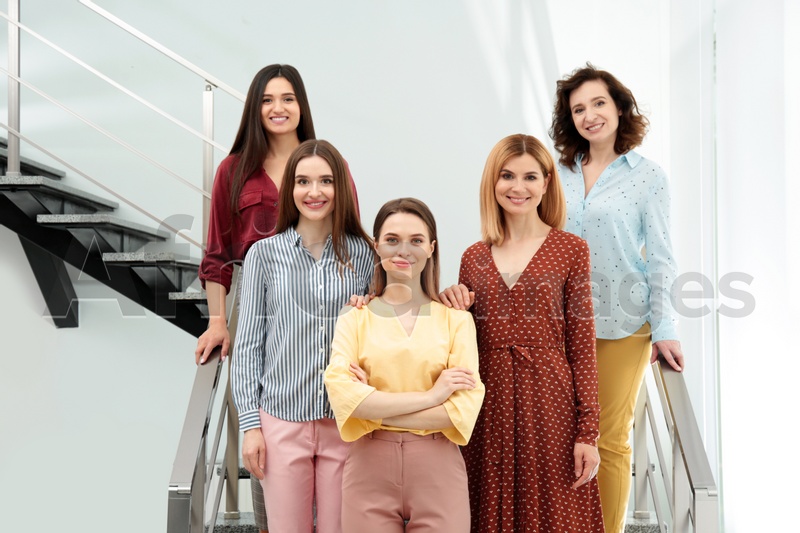 Portrait of happy ladies on stairs indoors. Women power concept