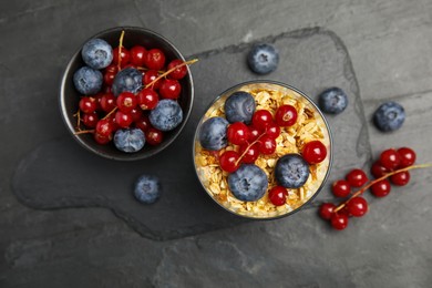Delicious yogurt parfait with fresh berries on black table, flat lay