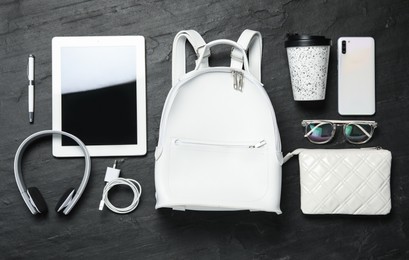 Stylish urban backpack and different items on black table, flat lay
