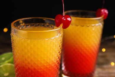 Fresh alcoholic Tequila Sunrise cocktails on wooden table, closeup