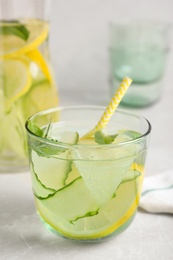Refreshing water with cucumber, lemon and mint on white table, closeup