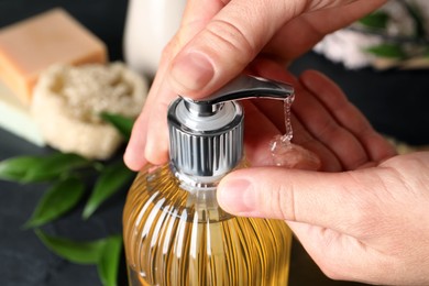 Woman using liquid soap dispenser, closeup view