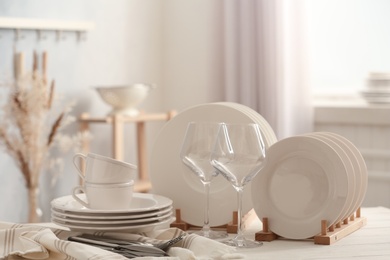 Set of clean dishware, cutlery and wineglasses on white table indoors