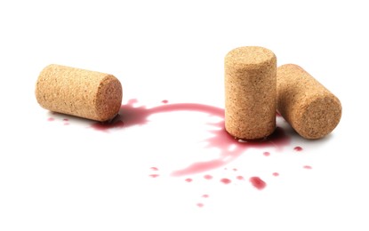 Bottle corks with wine stains on white background