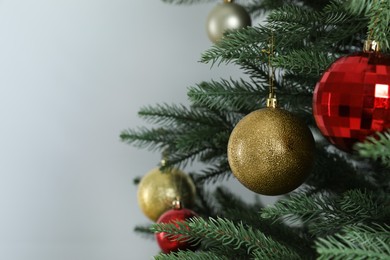 Beautiful Christmas tree with shiny baubles on white background, closeup. Space for text